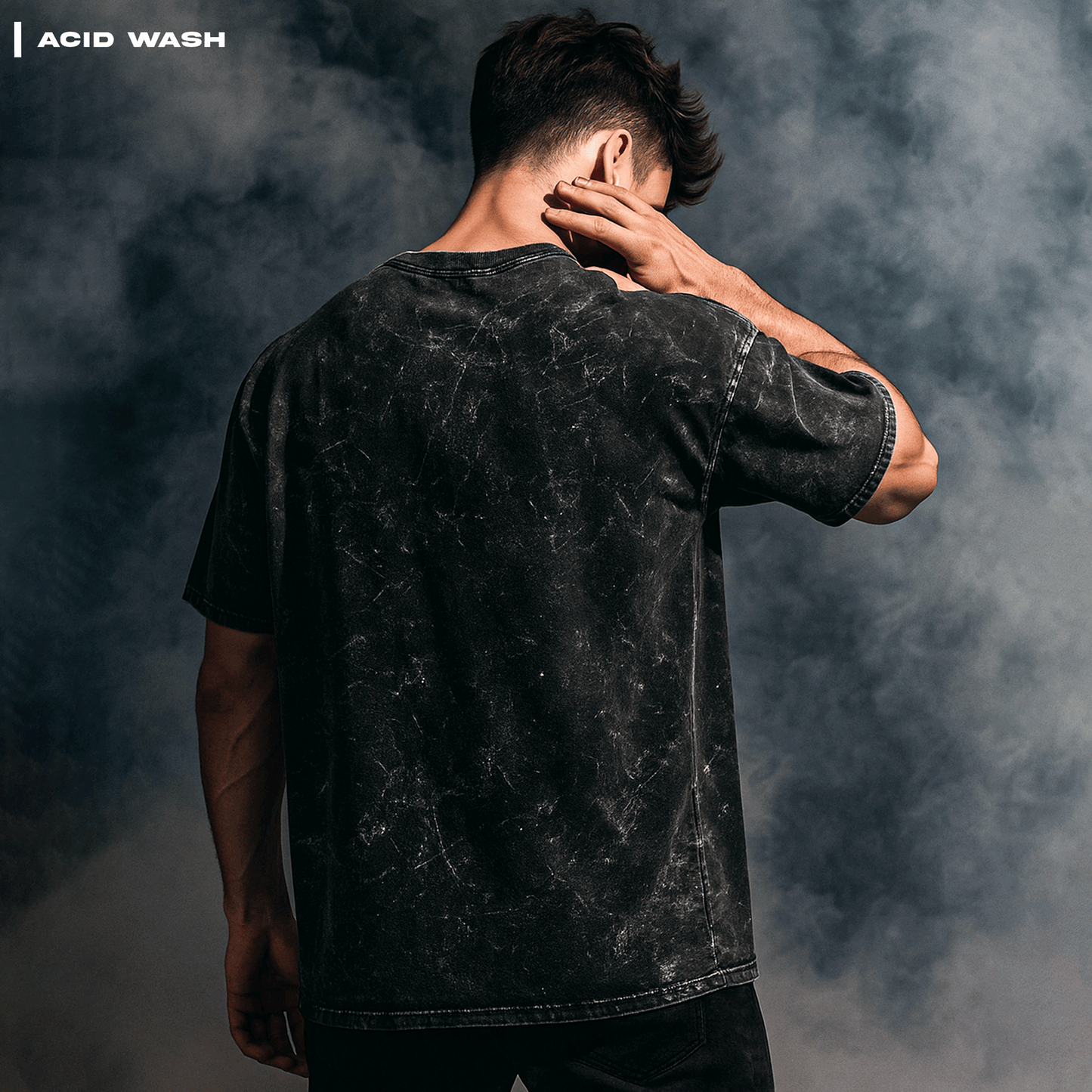 Person wearing an acid-wash black t-shirt against a textured gray background Trinetra T-shirt Covert