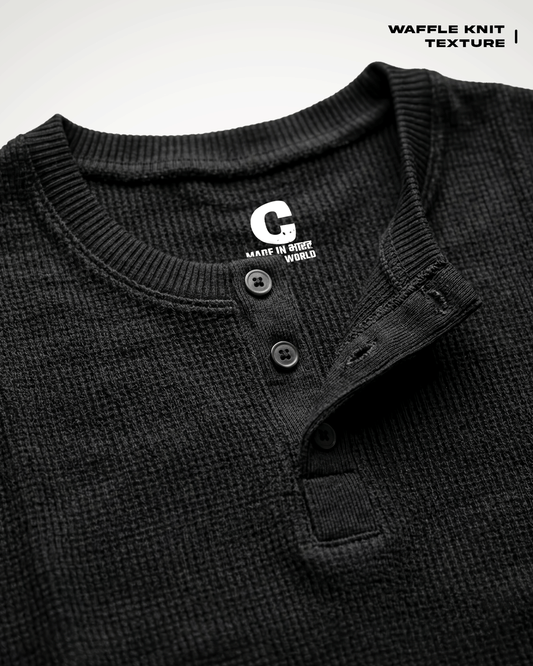 Close-up of a Waffle Knit Henley Full Sleeve T-shirt with a button placket and ribbed collar, showing a white 'G' logo on the inside neck label. Text in the top right reads 'WAFFLE KNIT TEXTURE'.