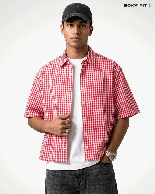 A man wearing a Red Madras Check Shirt boxy fit shirt by Covert over a white t-shirt, paired with dark gray jeans and a black baseball cap. The text 'BOXY FIT |' is visible in the top right corner.