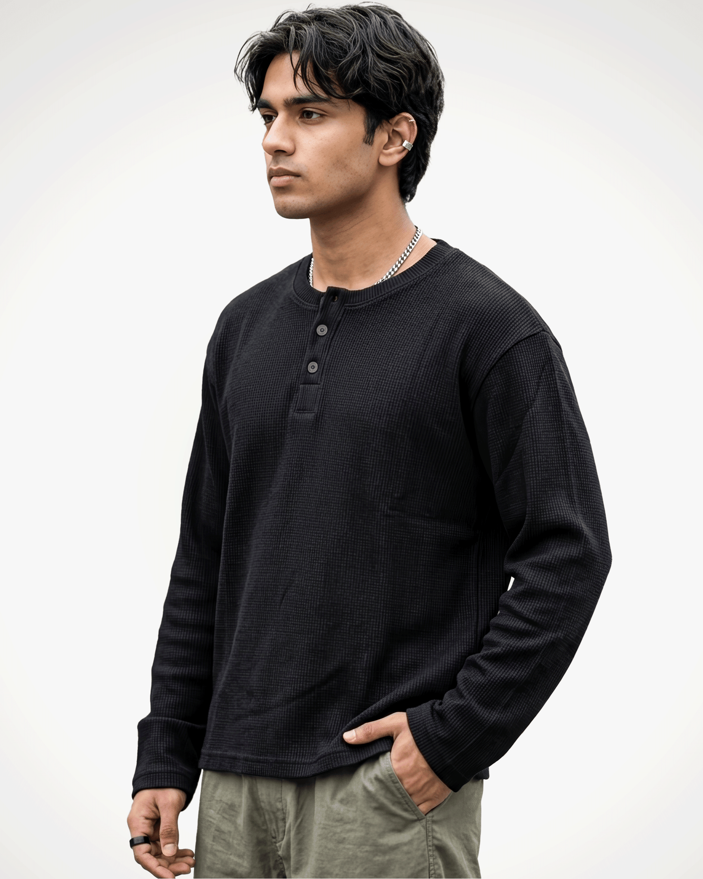 A man wearing a Waffle Knit Henley Full Sleeve T-shirt and olive green pants, standing against a light gray studio background.