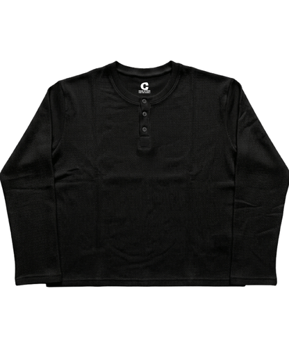 A black Waffle Knit Henley Full Sleeve T-shirt with a three-button placket, laid flat against a white background. The inside collar features a white circular logo with a 'C' and the text 'CANVAS'.